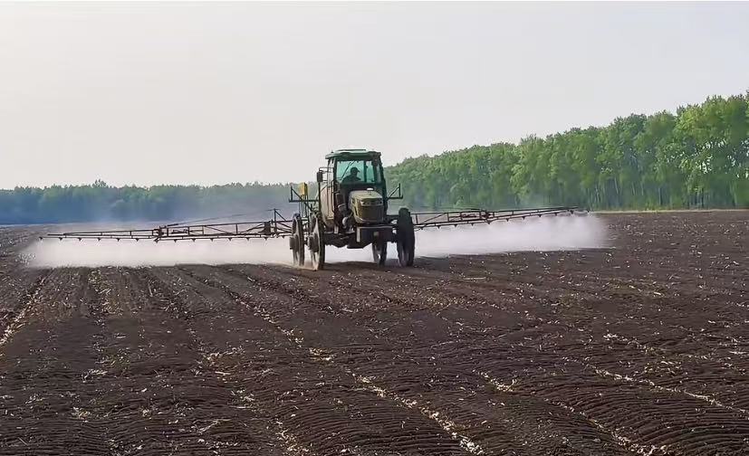 Agricultural spraying machine operating in a crop field